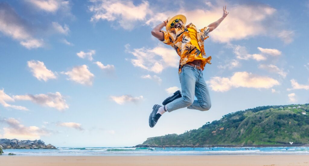 African man jumping celebrating holidays on the beach