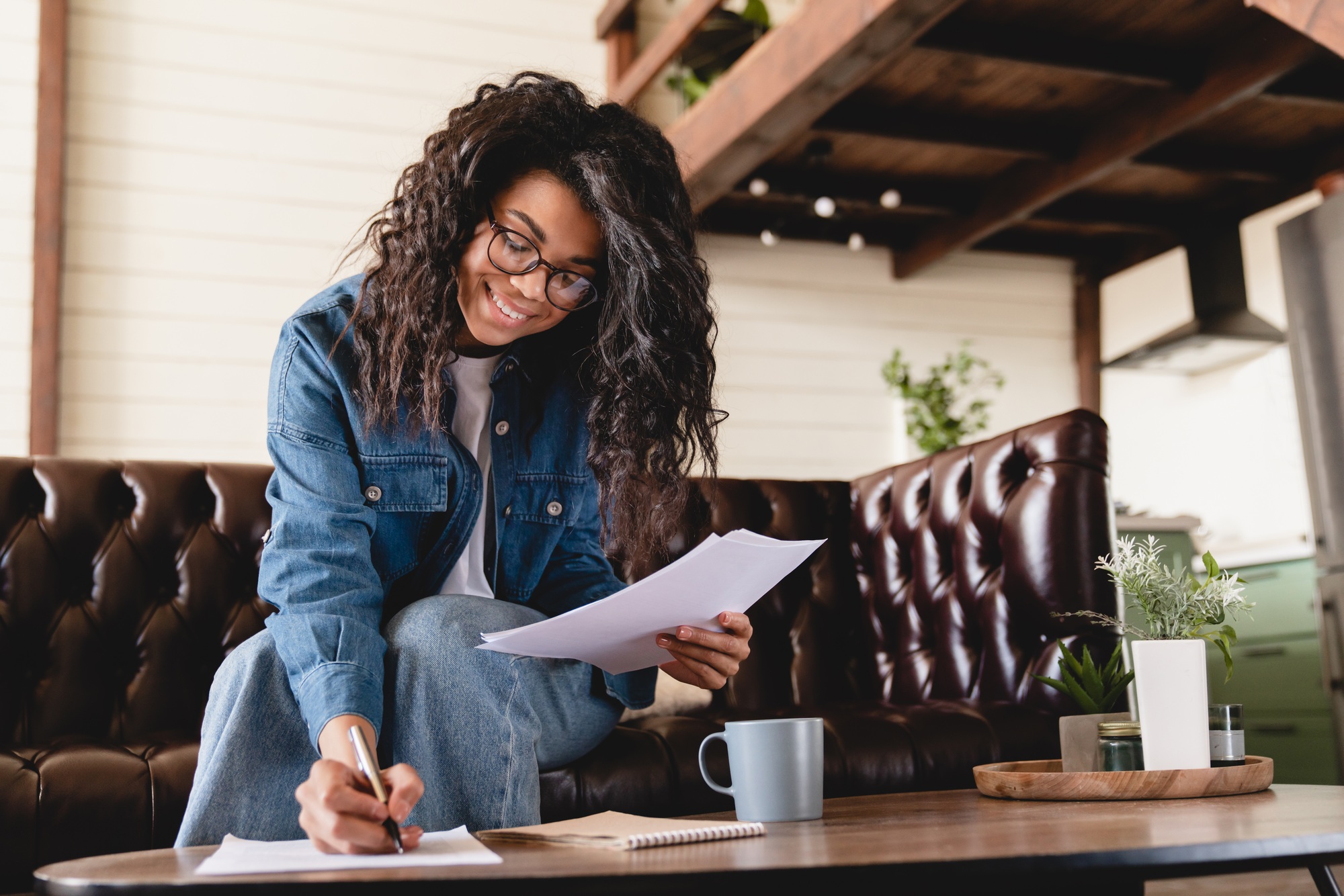 Busy young african businesswoman working with documents at home. African woman managing