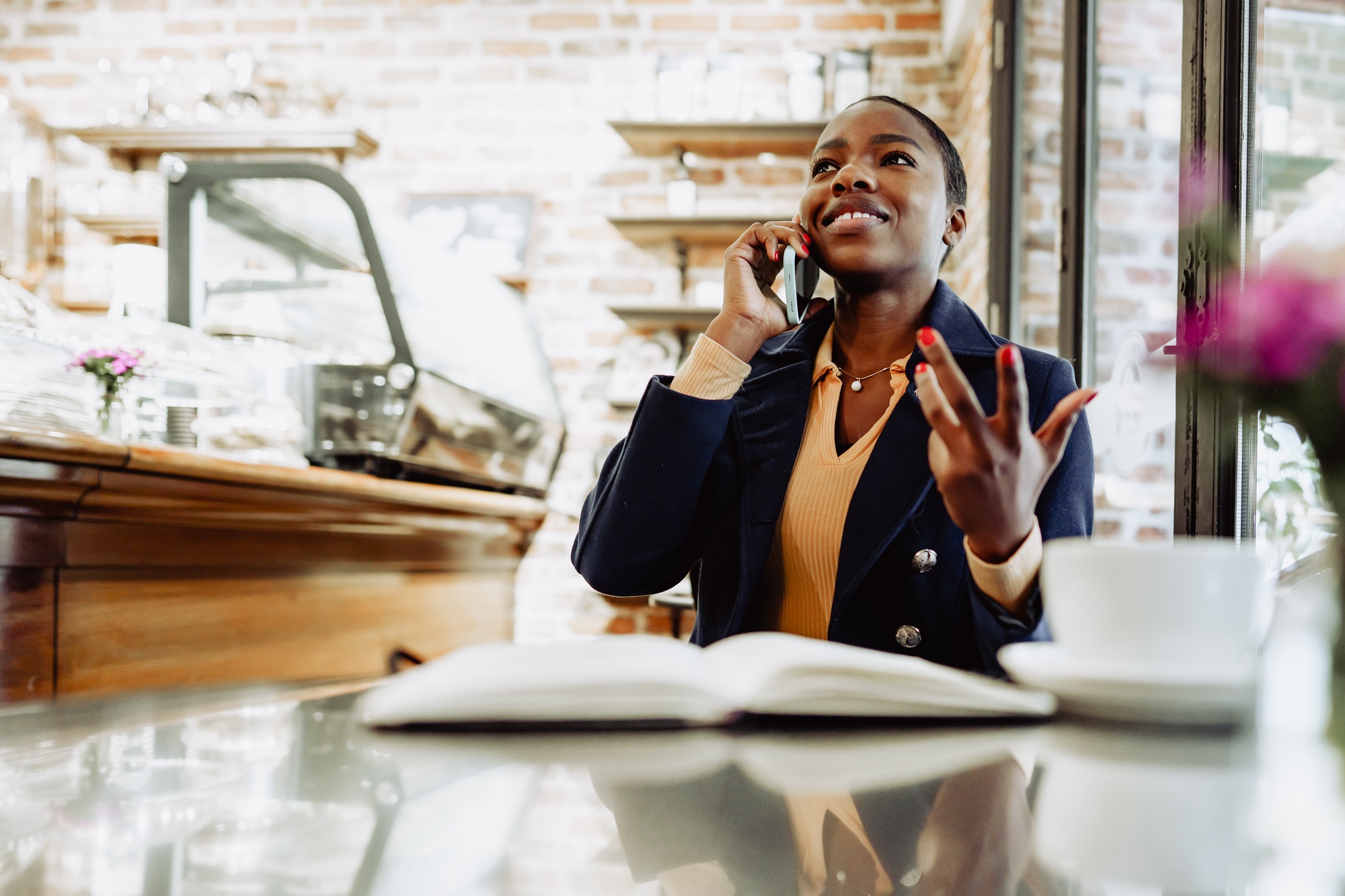 Happy african woman in cafe talking on the phone